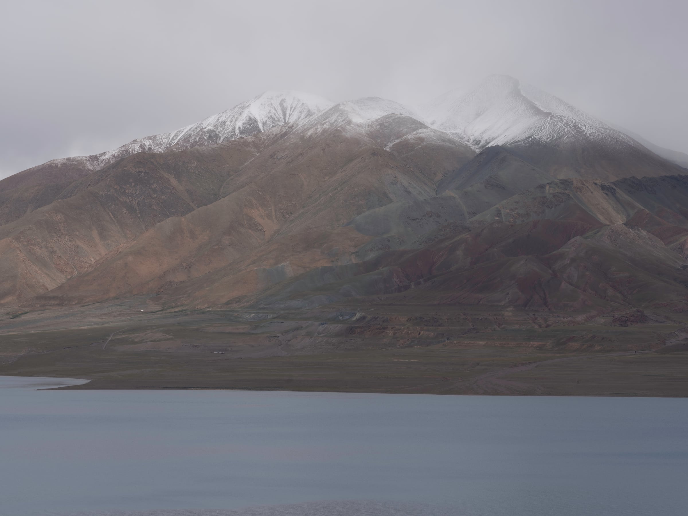 Mountains rising above a lake under a cloudy sky